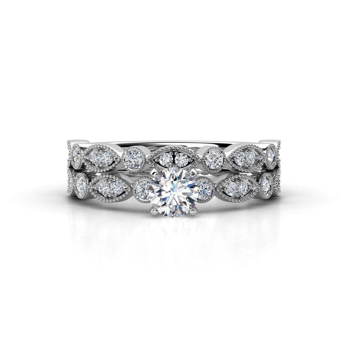Vintage-inspired diamond ring set with a solitaire diamond, marquise and round-cut accents, and intricate milgrain detailing.