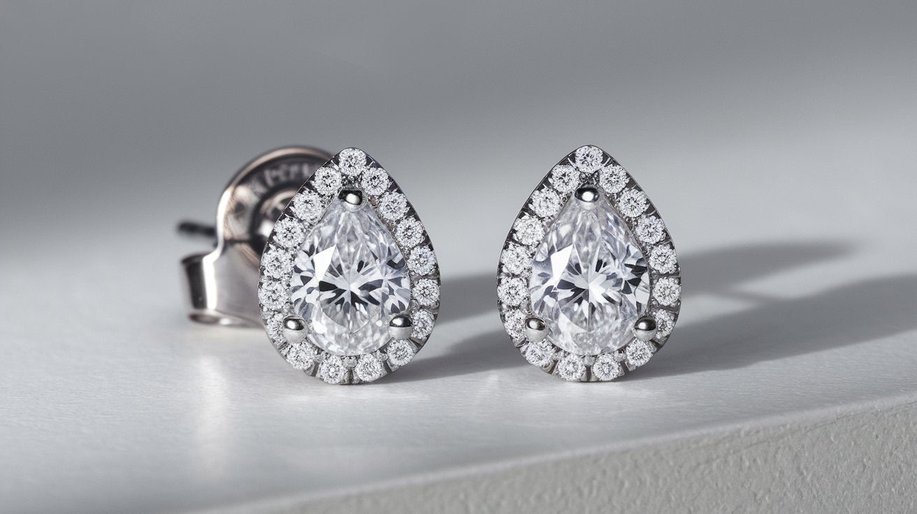 Pear-shaped lab-grown diamond halo stud earrings in white gold with sparkling accent diamonds.